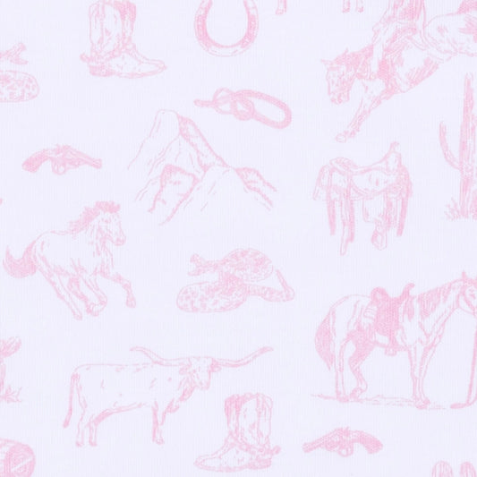 A close-up of a white fabric with a light pink western-themed toile pattern featuring horses, boots, hats, mountains, and a cowboy rifle.