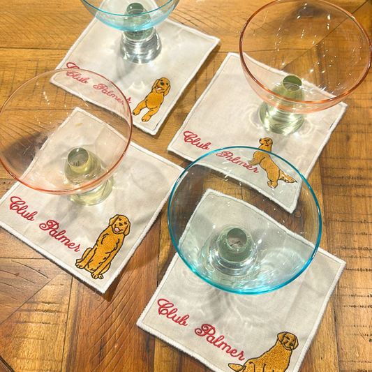 Club Palmer cocktail napkins custom white embroidered with personalized script and a yellow dog illustration