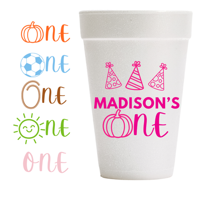 A white foam cup with custom printed pink text  and party hat graphics for a  first birthday