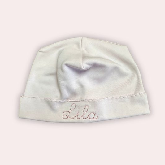 White baby hat with embroidered with custom name on with light pink thread