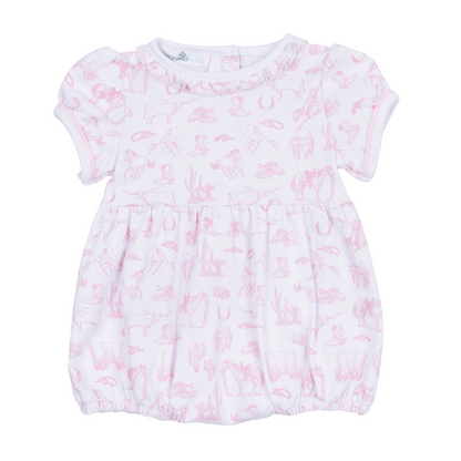 A baby girl's short-sleeve bubble in white cotton muslin with a light pink western-themed print, featuring a ruffled neckline and elasticized hem.
