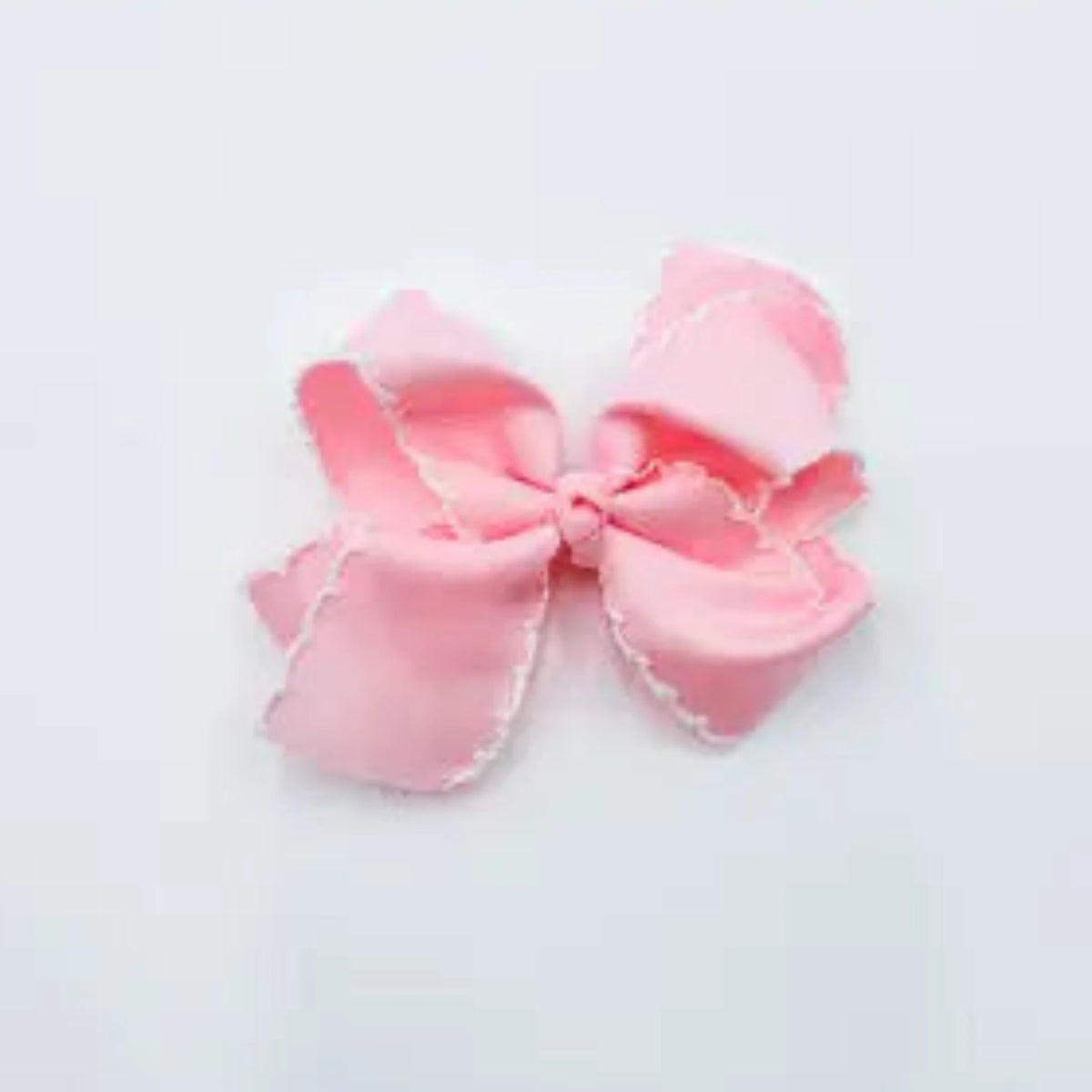 A light pink satin bow with delicate white scalloped edges,