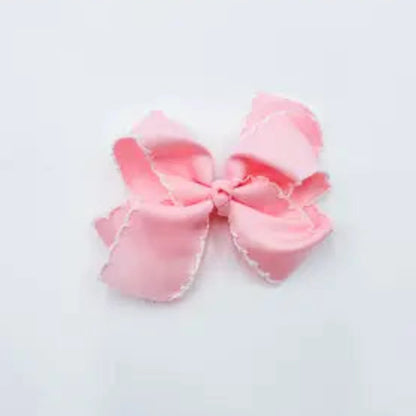 A light pink satin bow with delicate white scalloped edges,